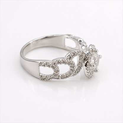 A silver-tone ring featuring a crown motif paved with small clear stones, with a larger clear central gemstone in a halo setting, shown on a white background.